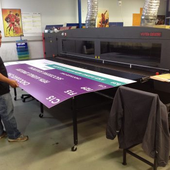 Experienced staff member working on commercial printer during a season of change and uncertainty in business